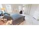 Bright main bedroom with two windows, white decor, tiled floors, and access to a balcony at 26089 Seminole Lakes Blvd, Punta Gorda, FL 33955