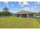 Wide shot of the large backyard with lush green grass extending to the home and screened-in porch at 27038 San Jorge Dr, Punta Gorda, FL 33983
