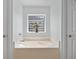 Bathroom features a large soaking tub nestled between two doors and a decorative glass block window at 27038 San Jorge Dr, Punta Gorda, FL 33983
