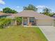 Charming one-story home featuring a well-maintained lawn and a welcoming entrance with decorative palm trees at 27038 San Jorge Dr, Punta Gorda, FL 33983