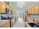 Kitchen features stainless steel appliances, wood cabinets, and a view into the sunroom at 27038 San Jorge Dr, Punta Gorda, FL 33983