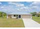 Charming single-story home featuring a clean driveway, neutral paint and a sturdy metal roof at 27050 Pelotas Dr, Punta Gorda, FL 33983