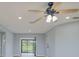 Bright living room featuring new light wood flooring, neutral paint, and a modern ceiling fan at 27050 Pelotas Dr, Punta Gorda, FL 33983