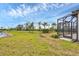 Expansive backyard with lush green grass, picturesque water view, and screened in lanai at 281 Potenza Loop, Nokomis, FL 34275