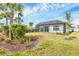 A spacious backyard with lush greenery, palm trees, and a screened-in lanai at 281 Potenza Loop, Nokomis, FL 34275