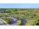 Aerial view of a well-maintained dog park with green space, surrounded by a natural landscape and a nearby road at 281 Potenza Loop, Nokomis, FL 34275