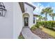Elegant front entrance featuring a stylish door, manicured landscaping, and a brick pathway at 281 Potenza Loop, Nokomis, FL 34275