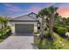 Charming single-story home with a two-car garage, a brick driveway, and lush tropical landscaping at 281 Potenza Loop, Nokomis, FL 34275