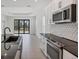 Bright kitchen offering stainless appliances, center island, and sliding door access at 281 Potenza Loop, Nokomis, FL 34275