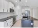 Modern kitchen with stainless steel appliances, a large island, and sleek countertops at 281 Potenza Loop, Nokomis, FL 34275