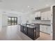 Stylish kitchen with a black island, white cabinets, and modern backsplash at 281 Potenza Loop, Nokomis, FL 34275