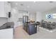 Well-lit kitchen featuring a dining area, island, stainless appliances, and backsplash at 281 Potenza Loop, Nokomis, FL 34275