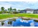 Lush greenery and a serene pond view enhance the backyard's appeal of this property at 281 Potenza Loop, Nokomis, FL 34275