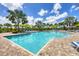 Beautiful pool area with inviting blue water, lounge chairs, and lush palm trees in a tropical community at 281 Potenza Loop, Nokomis, FL 34275