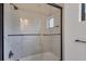 Modern bathroom shower with glass doors, neutral tile, and sleek black fixtures at 281 Potenza Loop, Nokomis, FL 34275