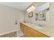 Well-lit bathroom with granite countertop, dual sinks, and wood-look flooring at 3021 Toluca Ter, North Port, FL 34286
