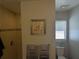Well-lit bathroom features a tiled shower, decorative art, and a functional toilet near a bright window at 3021 Toluca Ter, North Port, FL 34286
