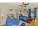 Bedroom with ceiling fan and two twin beds with galaxy design bedding at 3021 Toluca Ter, North Port, FL 34286