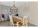 A modern dining area featuring a wood table, unique light fixture, and stylish decor at 3021 Toluca Ter, North Port, FL 34286
