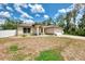 Single-story home with a two car garage, well-lit and welcoming with a long driveway and partially fenced yard at 3021 Toluca Ter, North Port, FL 34286