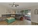 Bright living room featuring a large gray sofa and access to the pool area at 3021 Toluca Ter, North Port, FL 34286