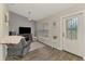 Comfortable living room featuring wood-look flooring, a large window, and a stylish front door at 3021 Toluca Ter, North Port, FL 34286