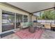 Covered patio with comfortable seating and stylish rug with a view of the backyard and pool at 3021 Toluca Ter, North Port, FL 34286