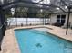 This screened pool features steps into the water, a tanning ledge, and serene backyard views at 3021 Toluca Ter, North Port, FL 34286