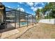 Screened pool with patio area with a straw umbrella and potted plants at 3021 Toluca Ter, North Port, FL 34286