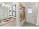 Bathroom featuring a marble sink, framed artwork, glass shower door, and rear exit door at 3301 Santa Barbara Dr, Punta Gorda, FL 33983