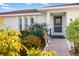 Charming front entrance with lush landscaping, a brick pathway, and a decorative storm door at 3301 Santa Barbara Dr, Punta Gorda, FL 33983