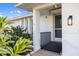 Front door with a ramp, a decorative light, and tropical landscaping at 3301 Santa Barbara Dr, Punta Gorda, FL 33983