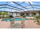 Screened pool area with a hot tub, patio furniture, and well-maintained landscaping at 3301 Santa Barbara Dr, Punta Gorda, FL 33983