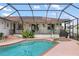 Inviting screened-in pool with a connected spa, patio area, and outdoor bar at 3301 Santa Barbara Dr, Punta Gorda, FL 33983