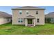 View of the back exterior featuring a covered patio, sliding glass door, and spacious backyard at 3941 River Bank Way, Punta Gorda, FL 33980