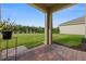 Outdoor patio with brick flooring, supporting pillars, and green grass, creating a serene outdoor living space at 3941 River Bank Way, Punta Gorda, FL 33980