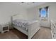 Well-lit bedroom with a patterned bed, white furniture, carpet floors, and a window showcasing the blue sky at 3941 River Bank Way, Punta Gorda, FL 33980