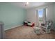 Cozy bedroom with light green walls, carpet flooring, and a window overlooking a green landscape at 3941 River Bank Way, Punta Gorda, FL 33980