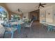 Covered clubhouse patio featuring tables, chairs, brick pavers, and ceiling fans at 3941 River Bank Way, Punta Gorda, FL 33980