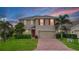 Charming two-story home with red shutters, a brick driveway, and a well-manicured lawn at 3941 River Bank Way, Punta Gorda, FL 33980