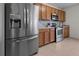 Modern kitchen with stainless steel appliances, wood cabinets, and a stylish tile backsplash at 3941 River Bank Way, Punta Gorda, FL 33980
