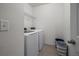 Functional laundry room with modern appliances, wire shelving, and tiled floors for easy maintenance at 3941 River Bank Way, Punta Gorda, FL 33980