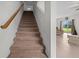 Carpeted staircase with wooden railing leading to the upper level at 3941 River Bank Way, Punta Gorda, FL 33980