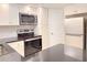 Well-equipped kitchen with stainless steel microwave, range, and refrigerator at 4158 Tamiami Trl # A5, Port Charlotte, FL 33952