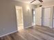 Spacious bedroom features wood-look floors, ceiling fan, and ensuite bathroom at 4158 Tamiami Trl # A5, Port Charlotte, FL 33952