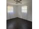 Bright bedroom features two windows with sheer curtains and sleek, dark wood flooring at 514 Showalter Ave, Punta Gorda, FL 33950