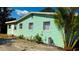 Side view of the home featuring horizontal siding, mature palms, and multiple windows at 514 Showalter Ave, Punta Gorda, FL 33950
