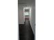 Hallway with dark floors, white walls, and white trim leading to kitchen with light at 514 Showalter Ave, Punta Gorda, FL 33950