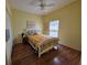 Cozy bedroom featuring hardwood floors, a ceiling fan, and a bright window at 5800 Sabal Trace Dr # 1201, North Port, FL 34287