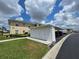 Exterior view showcasing a two-story condo, storage, covered parking, and well-manicured lawn at 5800 Sabal Trace Dr # 1201, North Port, FL 34287